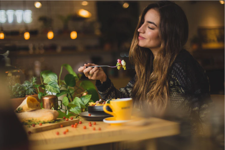 woman holding fork in front table photo